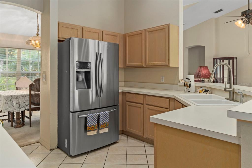5465 Chestnut Ridge Road Dade City, FL 33523 - Photo 12 of 37 a kitchen with granite countertop a refrigerator and a sink