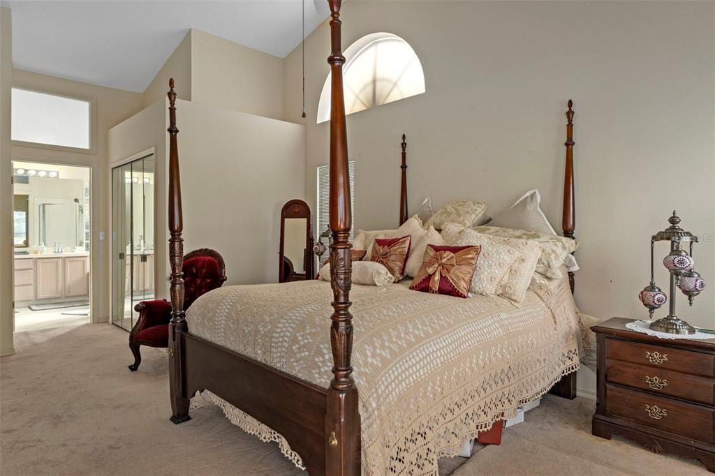 5465 Chestnut Ridge Road Dade City, FL 33523 - Photo 15 of 37 a bedroom with bed and a chandelier