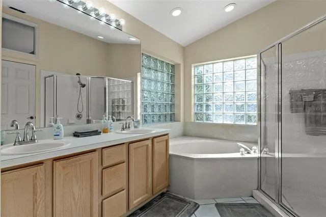 a bathroom with a large tub sink and double vanity