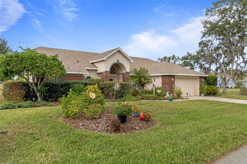 5465 Chestnut Ridge Road Dade City, FL 33523 - Photo 2 of 37 a front view of a house with garden