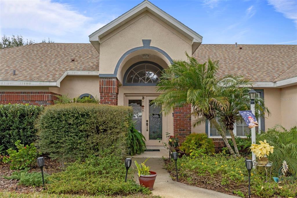 5465 Chestnut Ridge Road Dade City, FL 33523 - Photo 4 of 37 a front view of a house with a garden