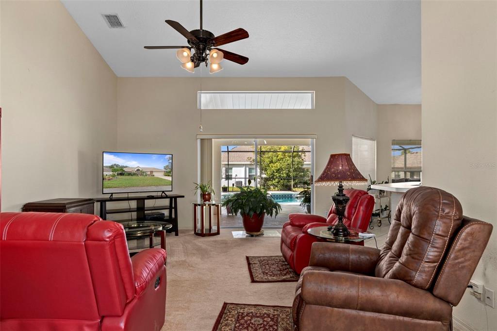 5465 Chestnut Ridge Road Dade City, FL 33523 - Photo 6 of 37 a living room with furniture a window and a flat screen tv