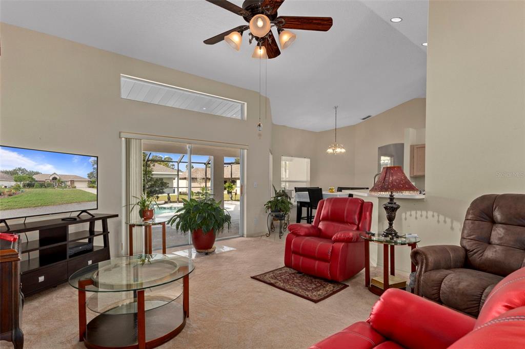 5465 Chestnut Ridge Road Dade City, FL 33523 - Photo 7 of 37 a living room with furniture a flat screen tv and a large window