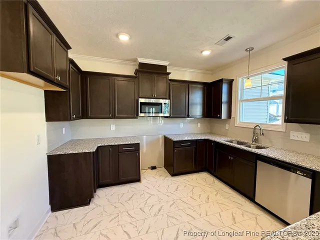 a kitchen with stainless steel appliances granite countertop a sink stove and microwave