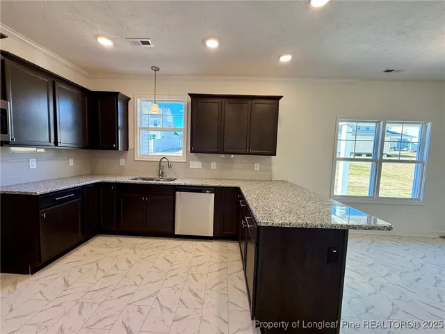 a kitchen with stainless steel appliances granite countertop a sink a stove a counter top space and a window