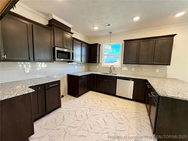 a kitchen with stainless steel appliances granite countertop a sink a stove top oven and granite counter tops