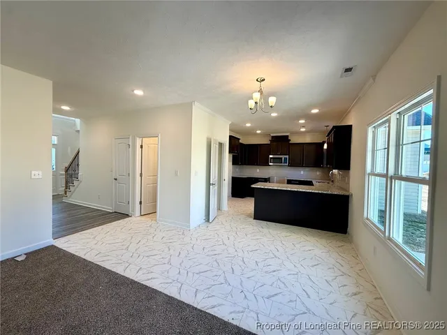 a large kitchen with stainless steel appliances kitchen island granite countertop a refrigerator and a sink