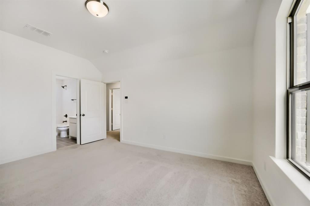 11465 Wulstone Road Fort Worth, TX 76052 - Photo 18 of 27 Carpeted room with a vaulted ceiling and an attached bathroom