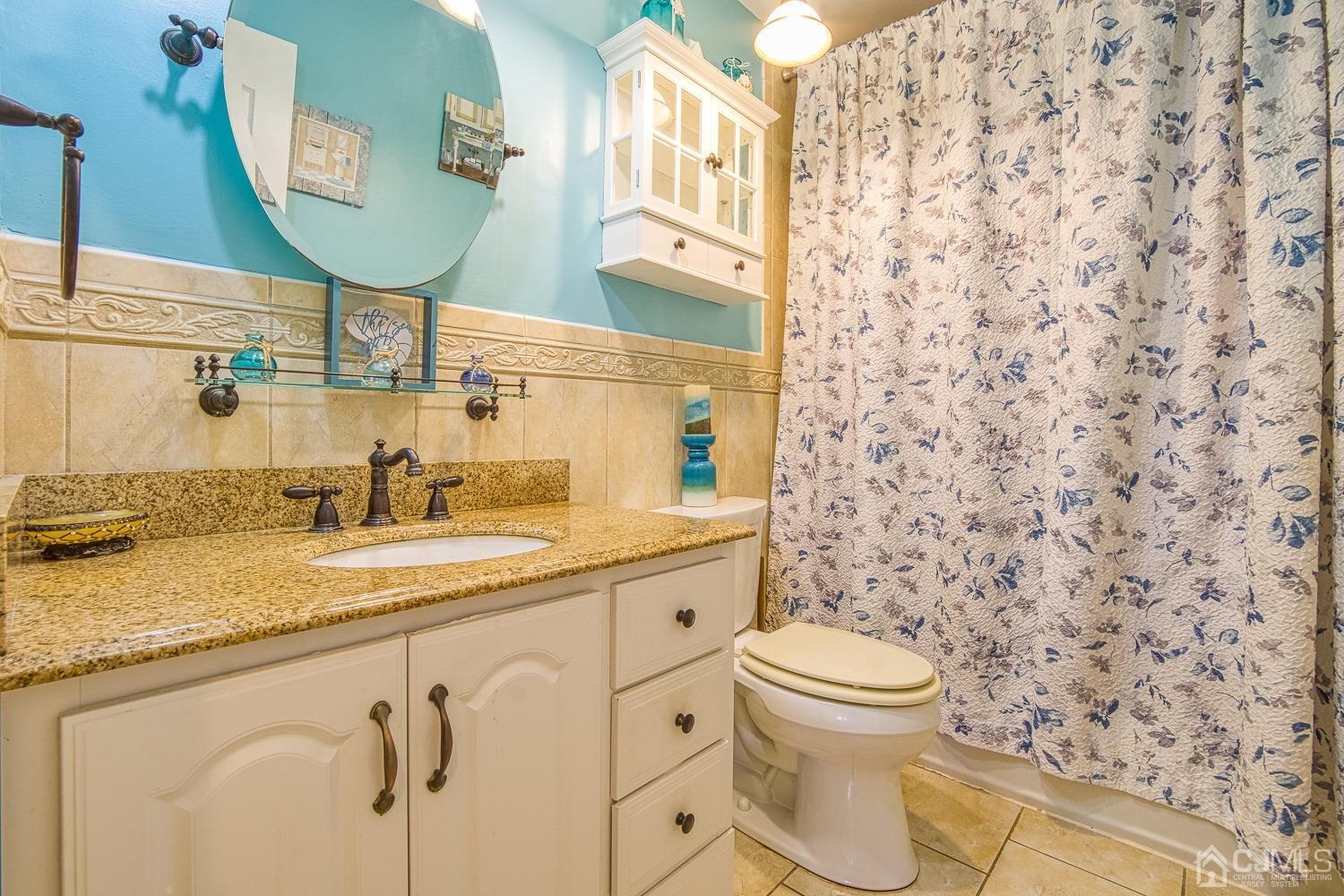 30 Kingsbridge Road Somerset, NJ 08873 - Photo 11 of 23 a bathroom with a granite countertop sink and a mirror