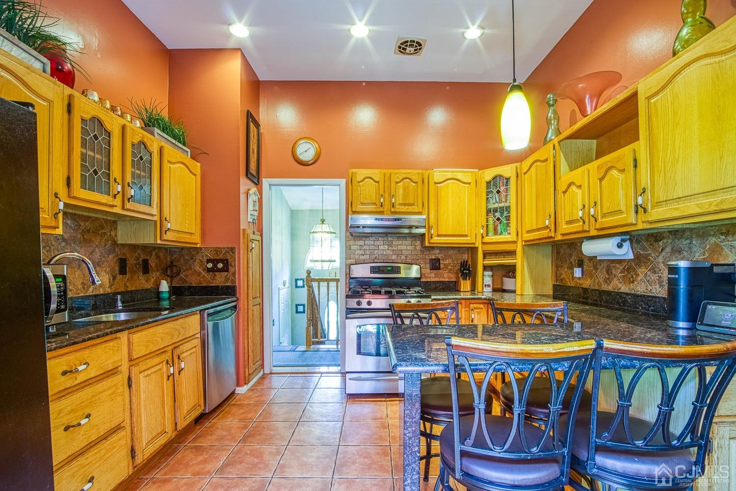 30 Kingsbridge Road Somerset, NJ 08873 - Photo 7 of 23 a kitchen with stainless steel appliances granite countertop a stove a sink and a refrigerator