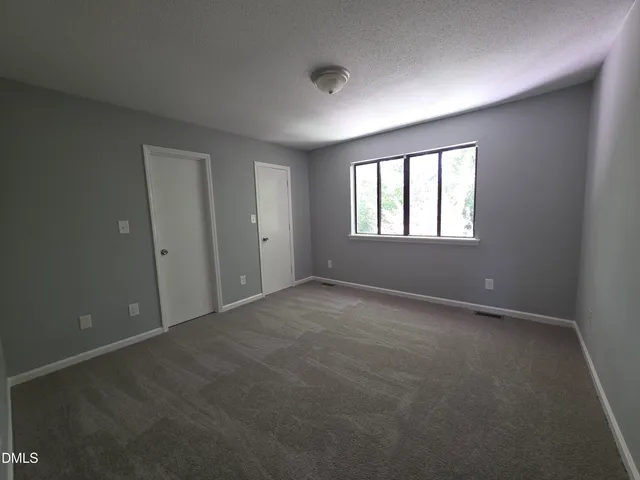 an empty room with windows and closet