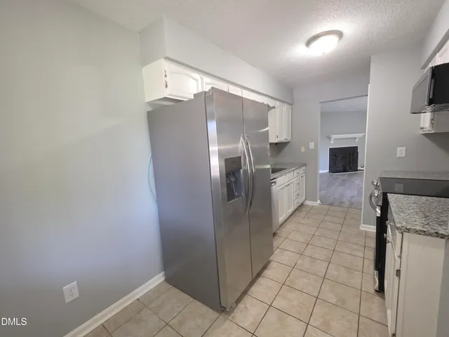 a kitchen with stainless steel appliances granite countertop a refrigerator and a stove