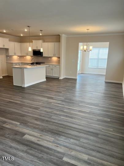 315 Villanova Drive Durham, NC 27713 - Photo 2 of 19 a view of a kitchen with kitchen island a sink wooden floor and a stove