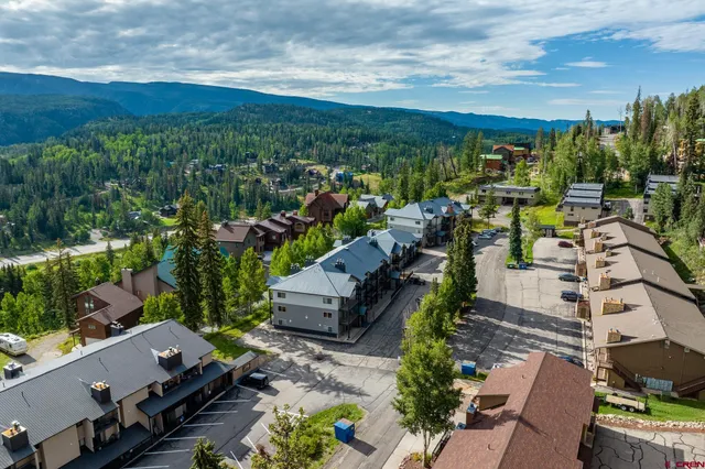 an aerial view of a city with lots of residential buildings and mountain view in back