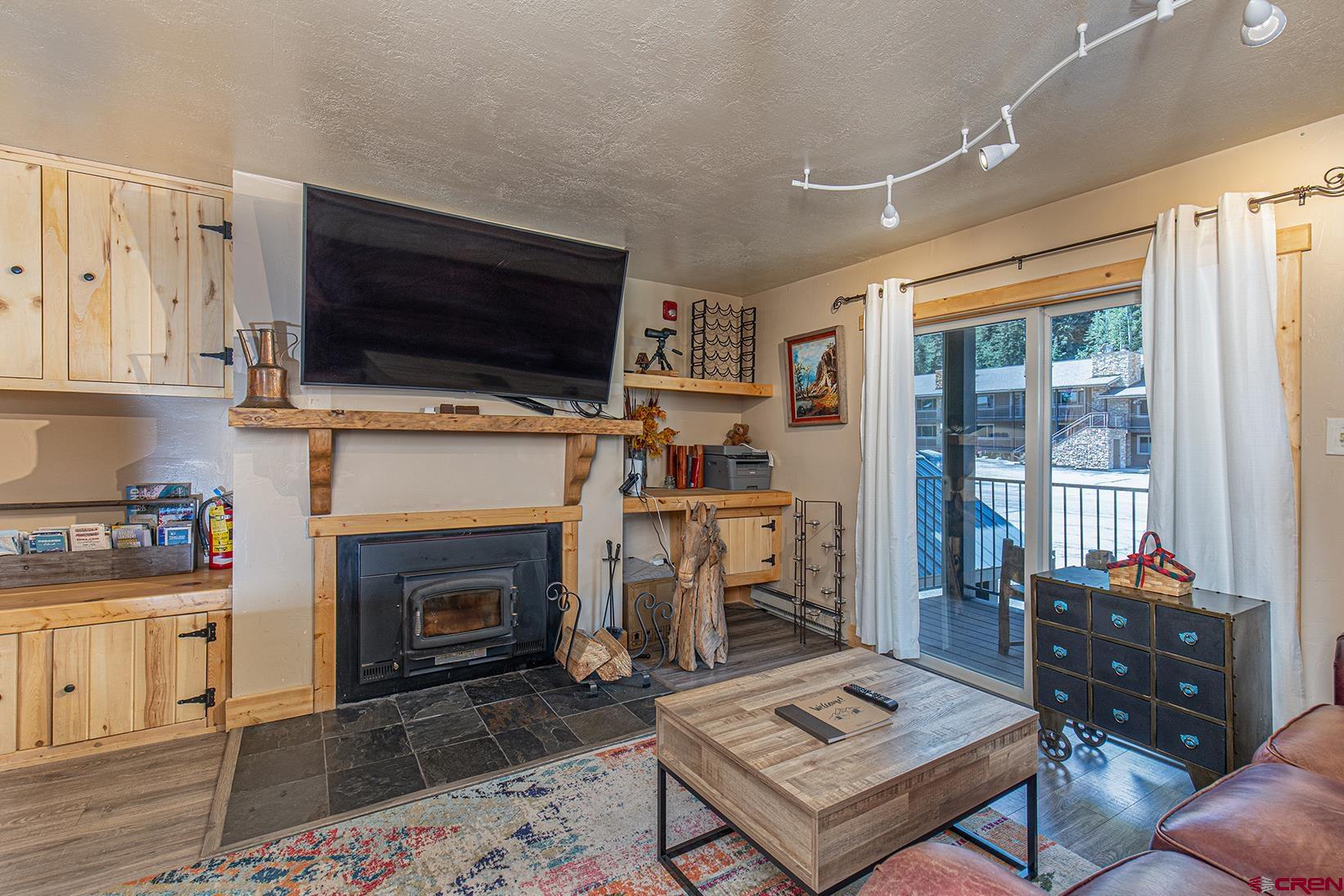 395 Sheol Street, Unit 37 Durango, CO 81301 - Photo 5 of 18 a living room with furniture a flat screen tv and a fireplace