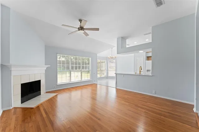 a view of empty room with wooden floor and fireplace