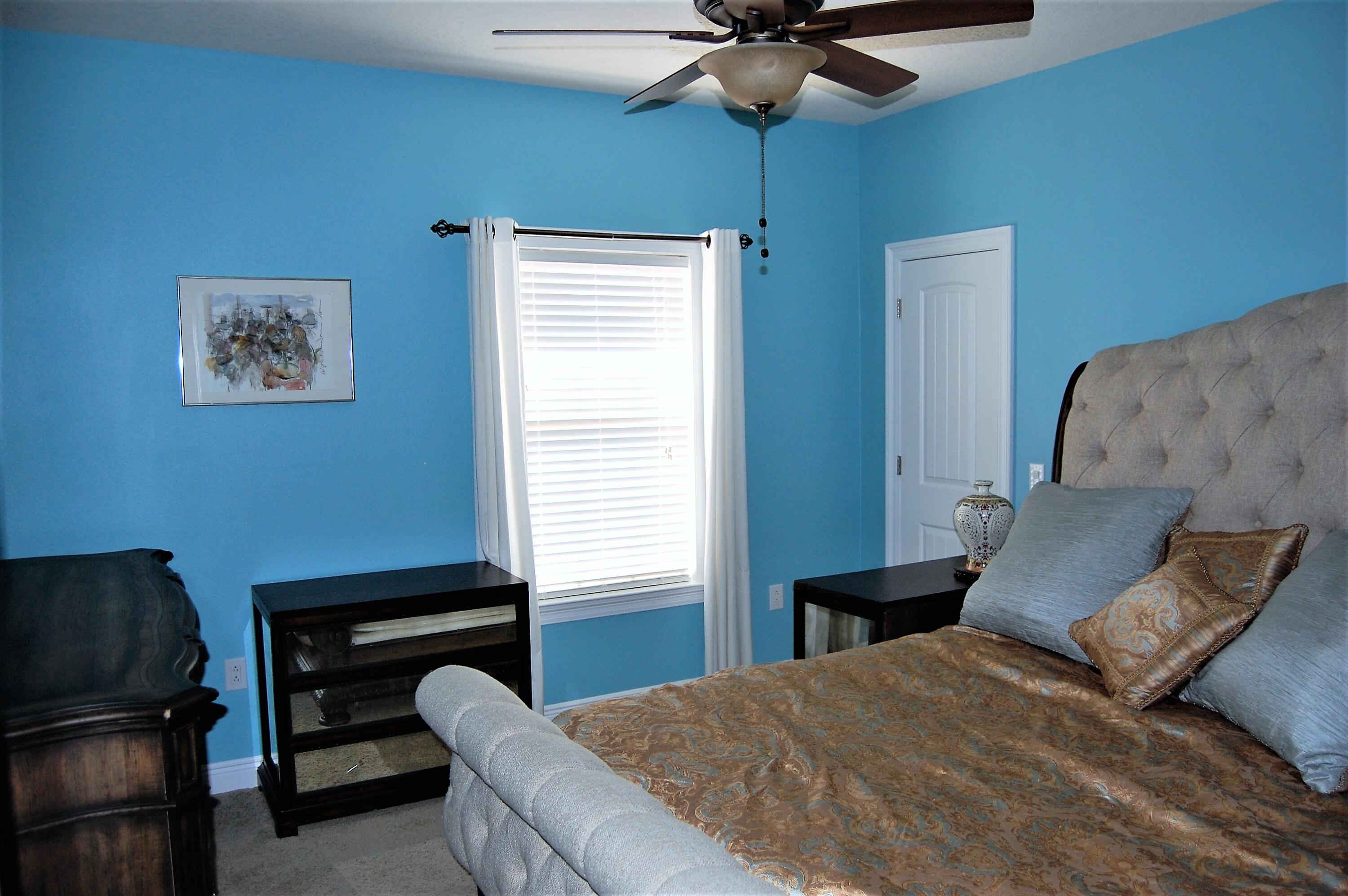 2497 Crescent Road Navarre, FL 32566 - Photo 31 of 51 a bedroom with a bed and a chandelier
