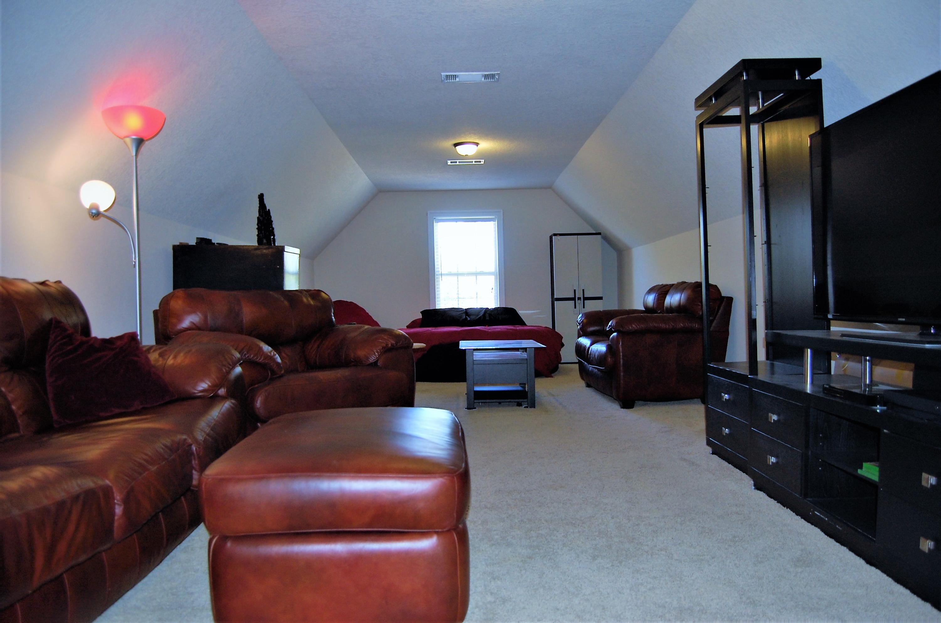 2497 Crescent Road Navarre, FL 32566 - Photo 37 of 51 a living room with furniture a lamp and a flat screen tv