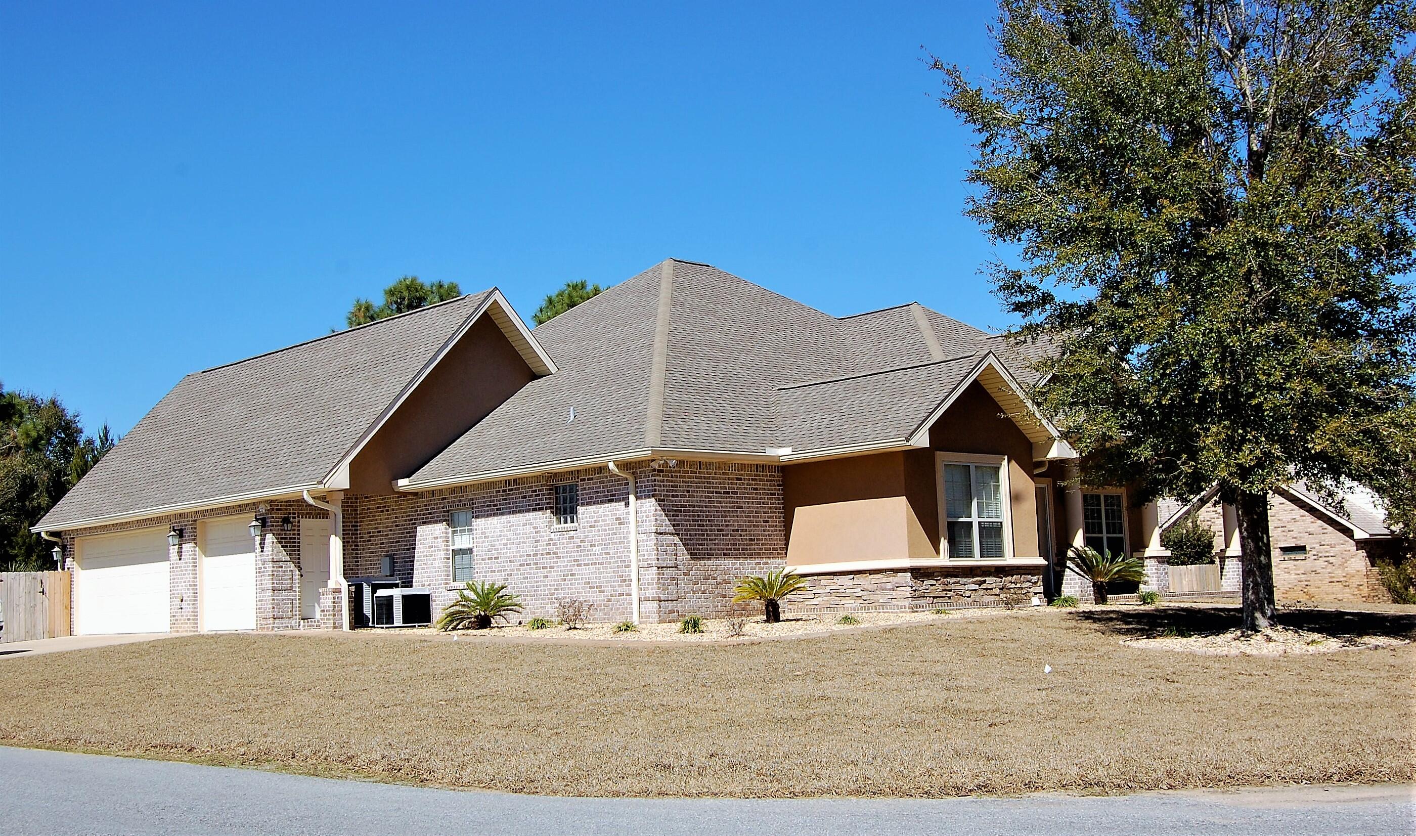 2497 Crescent Road Navarre, FL 32566 - Photo 4 of 51 a view of a house with a yard and garage