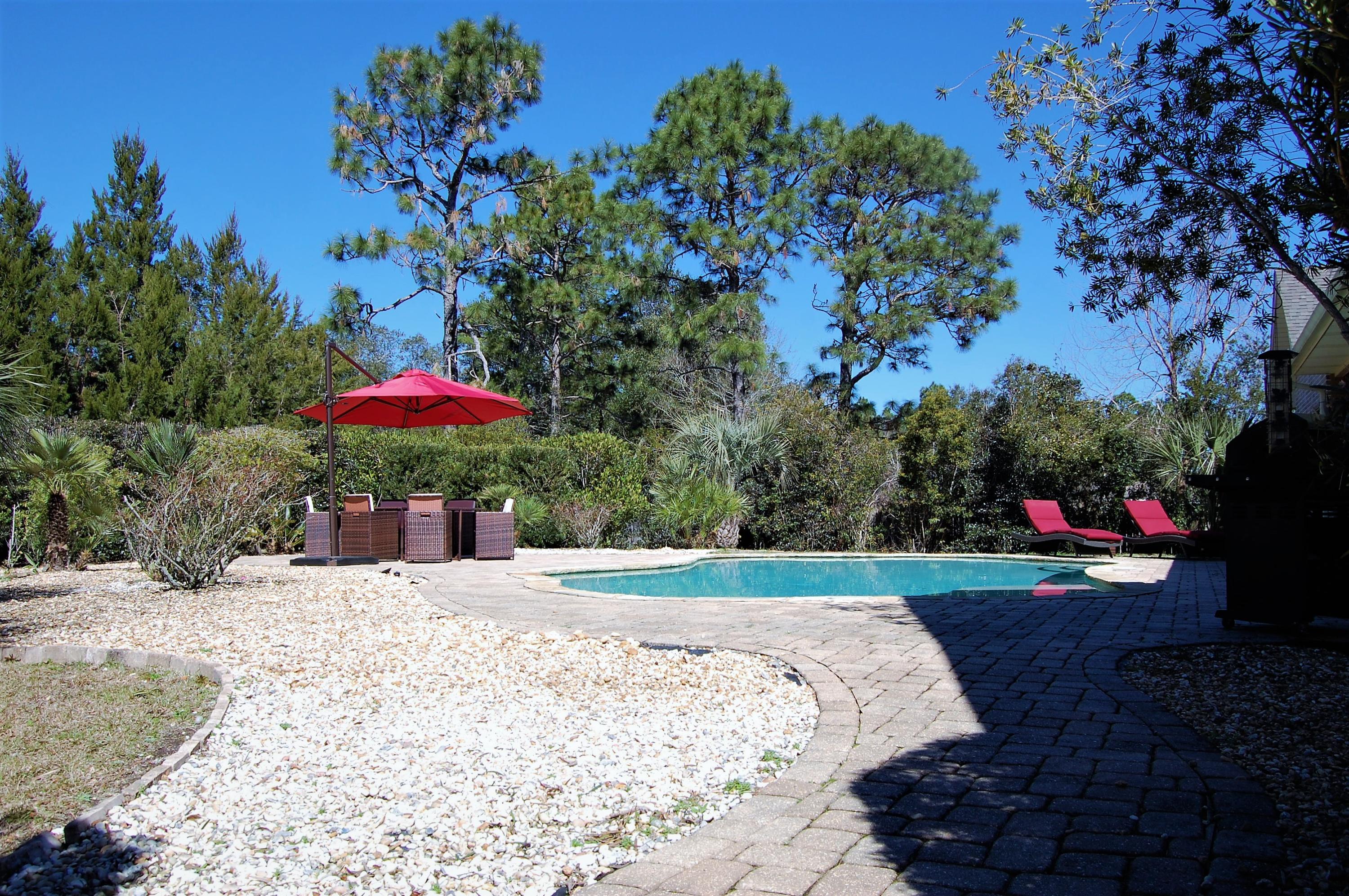 2497 Crescent Road Navarre, FL 32566 - Photo 44 of 51 a view of a backyard with a garden and fire pit