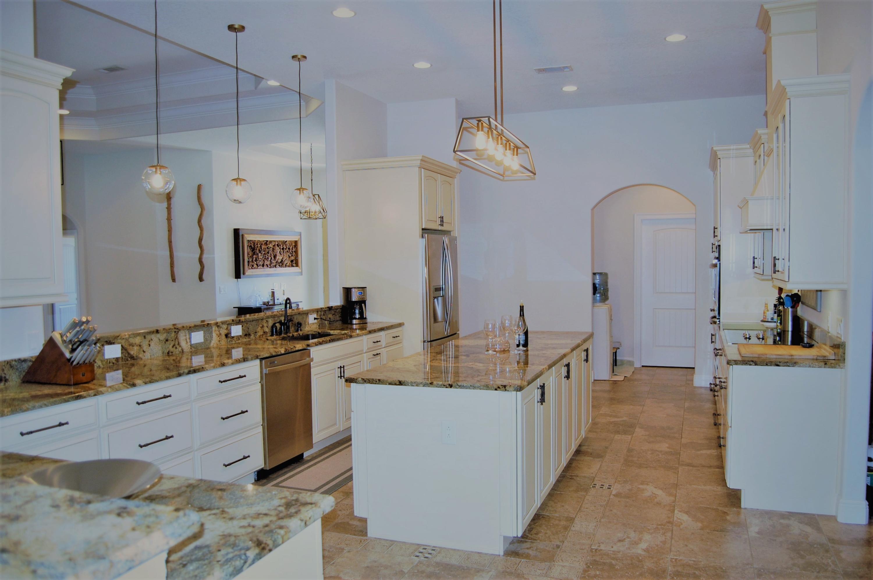 2497 Crescent Road Navarre, FL 32566 - Photo 8 of 51 a large kitchen with kitchen island a large counter top a sink stainless steel appliances and cabinets