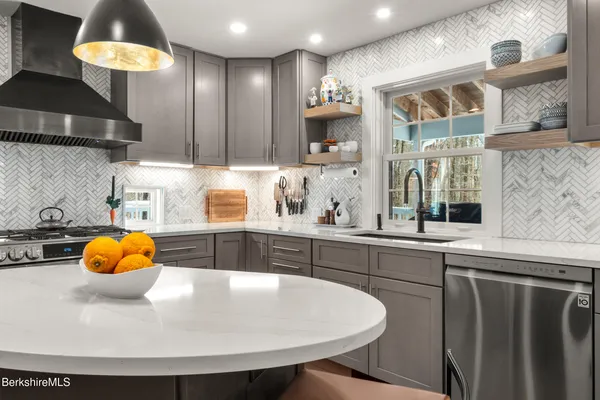 a living room with furniture a fireplace and kitchen view
