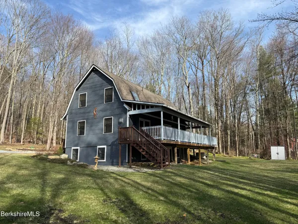 a kitchen with stainless steel appliances granite countertop a refrigerator a sink dishwasher a stove and white cabinets with wooden floor