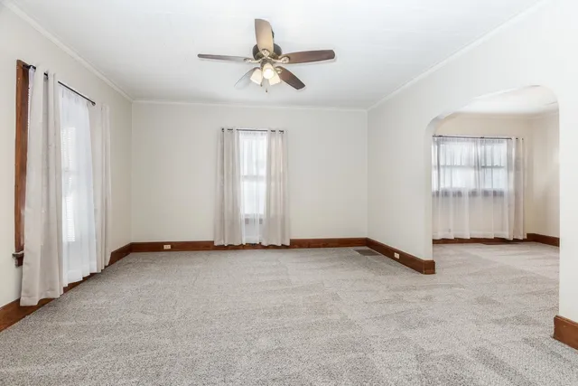 an empty room with closet and windows