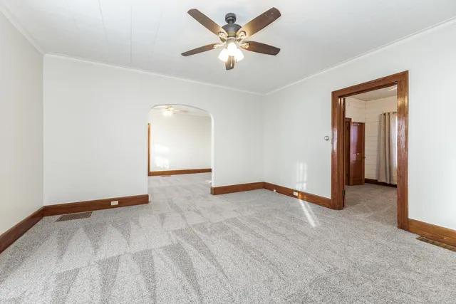 an empty room with closet and a ceiling fan