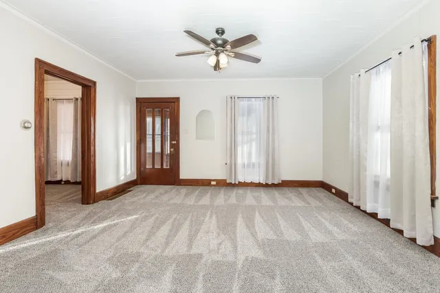 an empty room with fan and windows