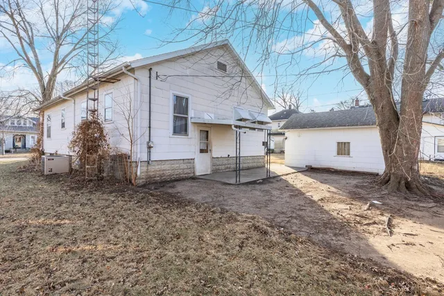 a view of a house with a yard and a tree