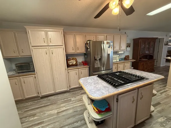 a kitchen with granite countertop stainless steel appliances a stove cabinets and wooden floor