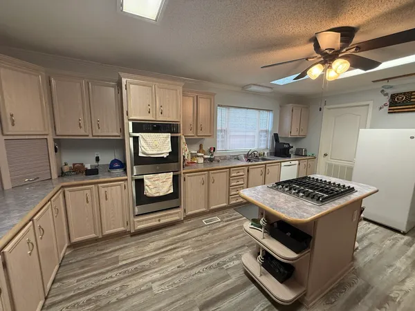 a view of a dining room and livingroom with furniture wooden floor a chandelier