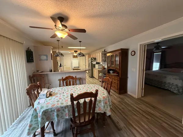 a kitchen with stainless steel appliances kitchen island granite countertop a refrigerator and chairs