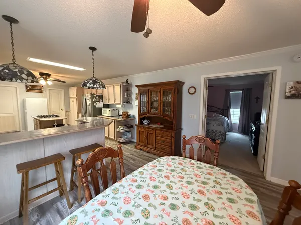 a kitchen with a refrigerator a sink and dishwasher a stove top oven with wooden floor