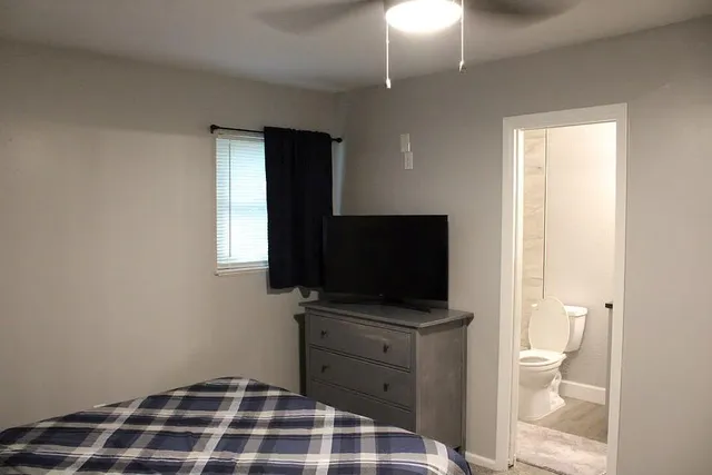 a bedroom with a bed and a flat screen tv