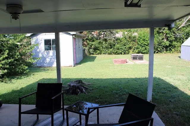 a view of a chairs and table in patio with a yard