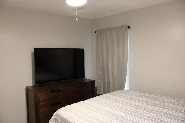 a bedroom with a bed and a flat screen tv