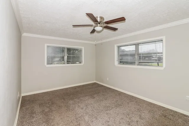 a view of a big room with wooden floor and windows