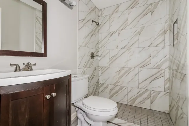 a bathroom with a granite countertop toilet sink and mirror