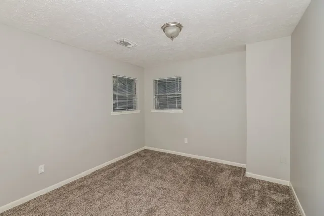 an empty room with a empty space and windows