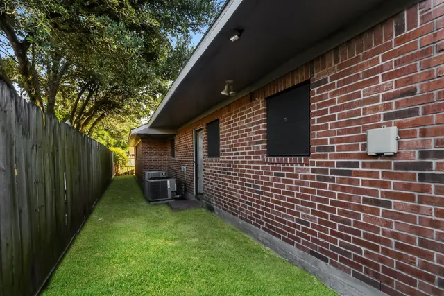 a backyard of a house with lawn chairs and wooden fence