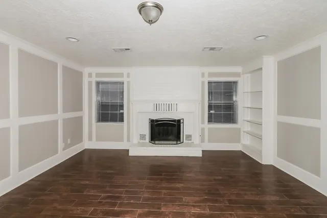 a view of a livingroom with a fireplace wooden floor and window