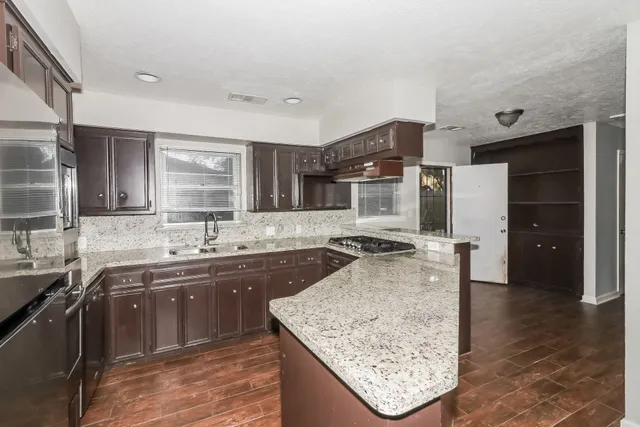 a kitchen with stainless steel appliances granite countertop a sink stove and refrigerator