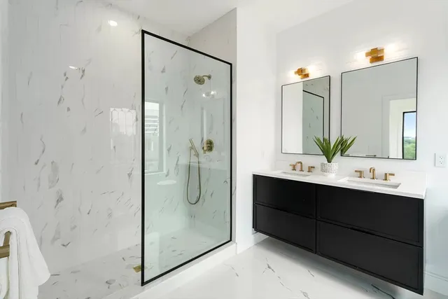 a bathroom with a double vanity sink mirror and shower