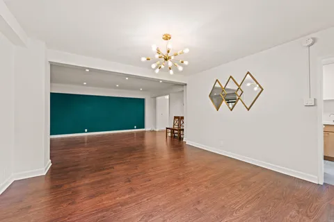 a view of a livingroom with wooden floor and a ceiling fan
