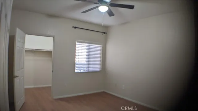 an empty room with a window and a fan