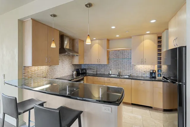 a kitchen with a sink a counter top space cabinets and stainless steel appliances