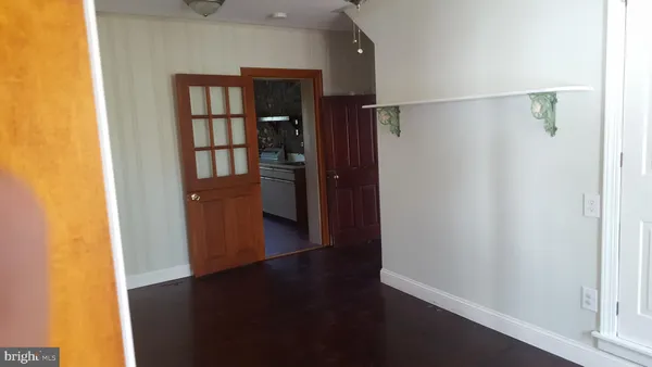 an empty room with wooden floor closet and windows