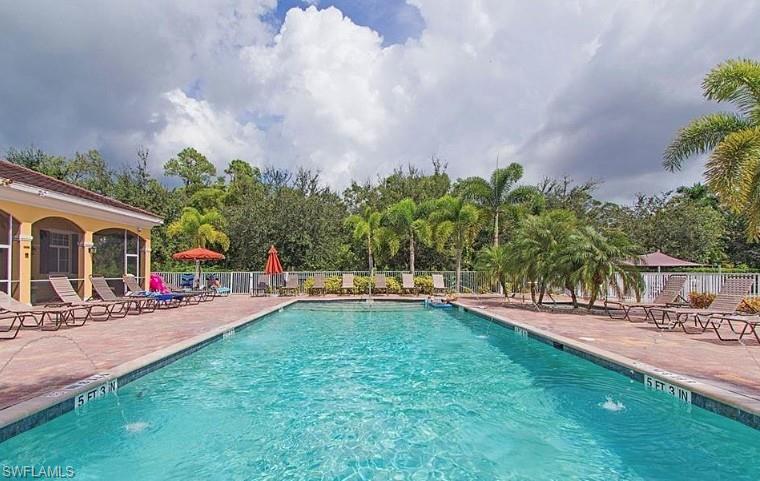 4430 Botanical Pl Circle, Unit 303 Naples, FL 34112 - Photo 17 of 22 a swimming pool with outdoor seating and yard